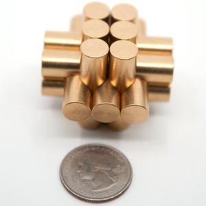 A miniture 13 piece cylindrical burr puzzle next to a regular US quarter i.e. a small puzzle not a giant coin.