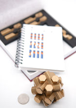 Load image into Gallery viewer, Assembled hex puzzle and the bonus items, 5 additional hex pieces and a booklet of additional problems and information.