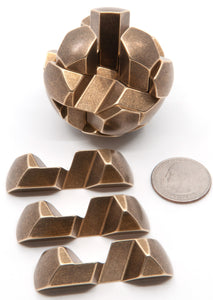 Metal Gumball spherical puzzle with three brass pieces removed and laid out beside the puzzle.